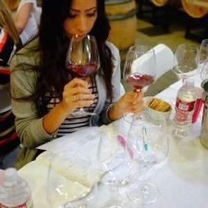 Woman tasting red wine at 90 Plus Wine Club event in Napa Valley.