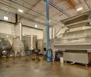 Wine fermentation tanks in a modern winery facility for 90 Plus Wine Club.