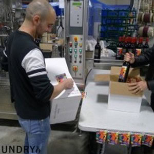 Man inspecting wine bottles at 90 Plus Wine Club production facility.